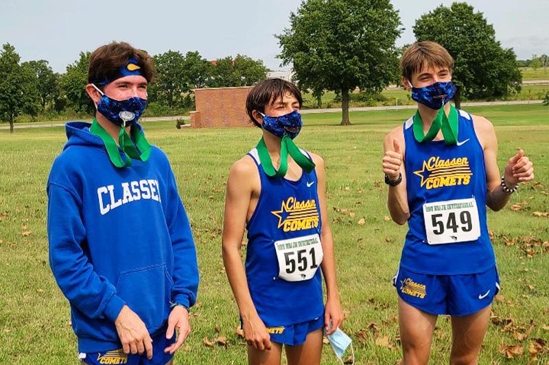 Aiden Kirkpatrick and other Classen SAS High School at Northeast cross country runners posing with their race medals