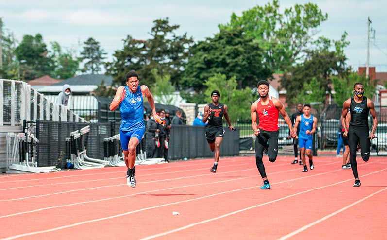 Fields & Futures All-City Track Meet Blog male high school student-athletes running in a relay race