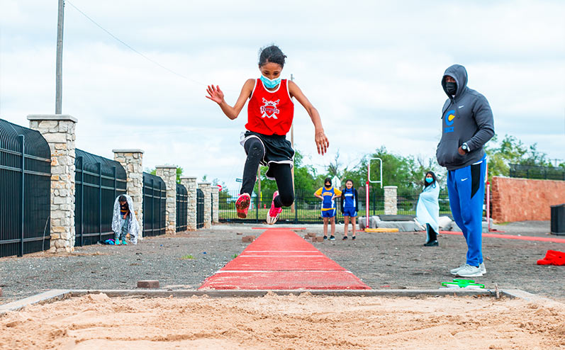 Fields & Futures All-City Track Meet Blog male middle school athlete competing in the long jump