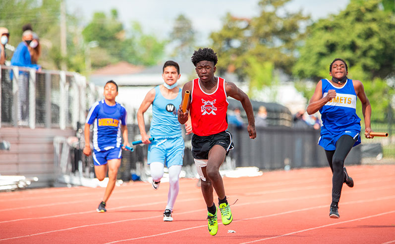 Fields & Futures All-City Track Meet Blog male middle school athletes competing in a relay race