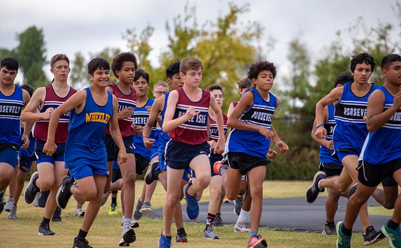 Fields & Futures Simon Greiner Track & Field Program Coach's Interview with John Zehr blog post story image of middle school cross country athletes from Oklahoma City Public Schools running in a cross country race