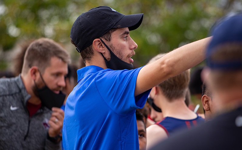 Fields & Futures Simon Greiner Track & Field Program Coach's Interview with John Zehr blog post story image of Coach Zehr directing his runners at a cross country meet